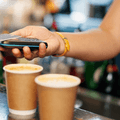person scanning credit card at coffee shop