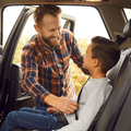 Dad buckling his son in the car