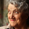 Older woman looking up smiling and thinking