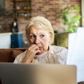 Older woman looking at papers worried face