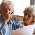 Older couple looking at paperwork worried