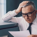 Finance man looking at document surprised and worried