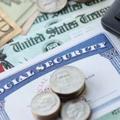 Social Security card with government check, cash, and a calculator