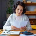 Older woman doing paperwork in her home office
