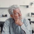 Contemplative older man on couch