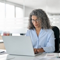 Middle aged business woman on laptop in office