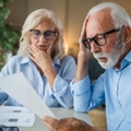 Older couple looking shocked when doing paperwork