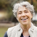 Happy woman in her 60s with short white hair smiling