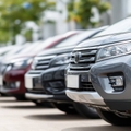Lineup of new cars parked at an outdoor dealership lot