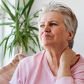 Woman in her 70s looking worried and in pain