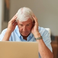 Stressed senior man on laptop