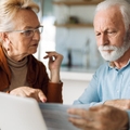 Senior couple reviewing paperwork in kitchen
