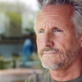 Pensive looking mature man looking out window