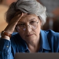 Stressed older woman on laptop