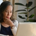 Mature woman on laptop in dining room