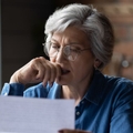Concerned older woman reviewing letter