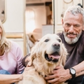 Couple in their 60s petting a dog
