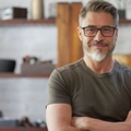 Smiling man in his 40s with crossed arms