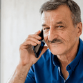 Man in his 60s on cell phone at home