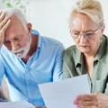 Worried senior couple looking at bills