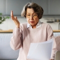 Senior woman surprised looking at paperwork