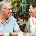 Couple in their 60s sitting outside having coffee