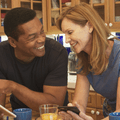 Couple in their 50s looking at tablet in kitchen