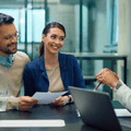 Young couple sitting with financial advisor at bank