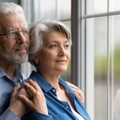 Senior couple looking through the window