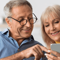 Older couple checking retirement accounts on phone