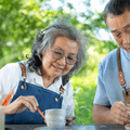 Senior couple doing pottery outside home