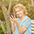 Senior retiree woman looking at investments on phone