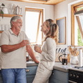 Couple in their 60s talking about social security in their kitchen