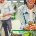 Woman using phone at grocery store