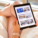 Woman holding iPad with Airbnb listings