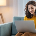 A woman sitting on the couch in her living room, using her laptop.