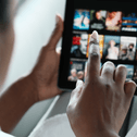 A woman scrolls through a streaming platform.
