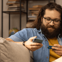 person holding credit card on couch with dog