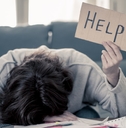 stressed woman holding up help sign