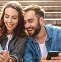 Happy couple looking at phones