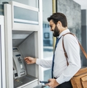 Businessman using card at an ATM