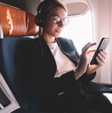 Woman sitting in business class using phone