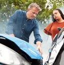 Two people looking at cars after accident