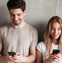 man and woman checking investments on phone