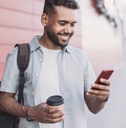 Man holding coffee and looking at phone