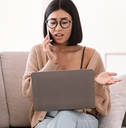 woman talking on mobile phone sitting on sofa