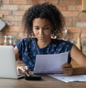 Woman looking at paperwork and using calculator