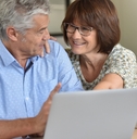 Senior couple talking and looking at computer