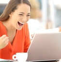 Woman cheering at computer screen