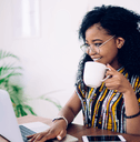 Woman with coffee working on laptop